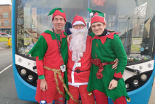 Santa and his elves in front of Santa bus
