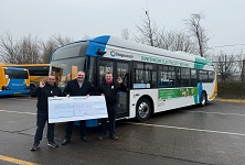 Cheque to Andy Mans Club infront of electric vehicle