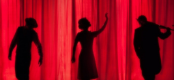 3 actors in front of a red curtain