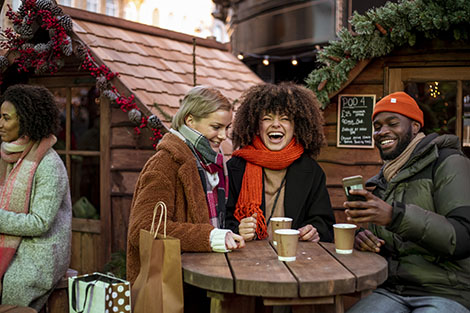 Three friends laughing at Christmas market 