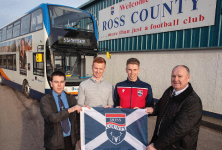 4 men holding flag outside football club