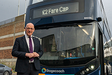 John Swinney, First Minister, standing next to a Stagecoach Bus.