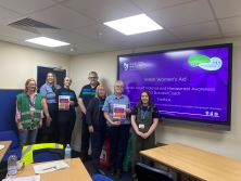 a group of people from Stagecoach and Dr Lucy Baker stood by a PowerPoint presentation.