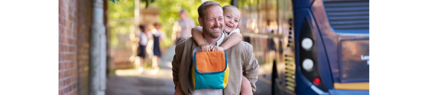 Father giving daughter piggyback after school
