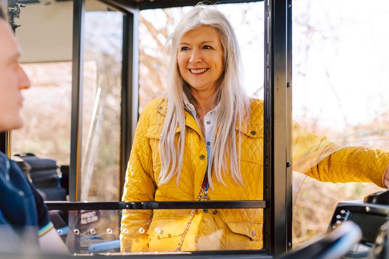 Lady in yellow jacket boarding bus