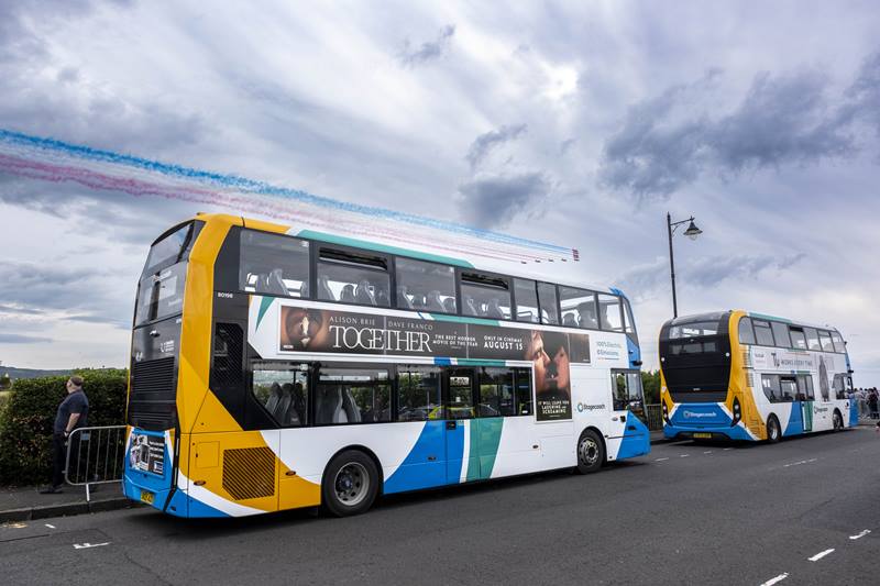 Double decker bus with Red Arrows flying pass