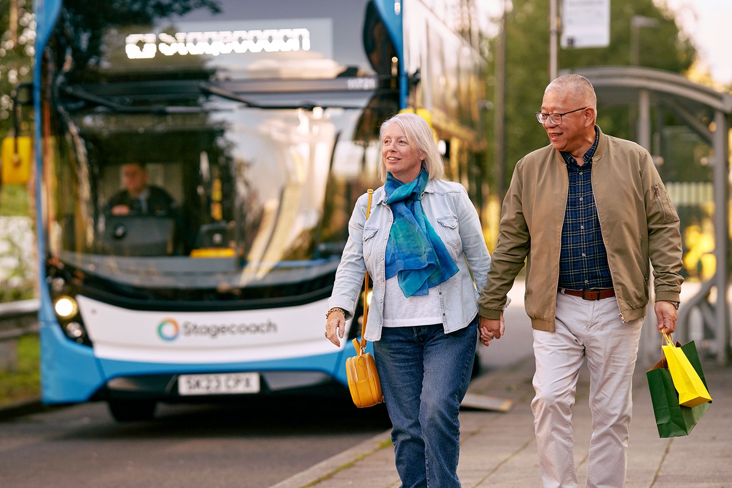Two people walking together with bus in background