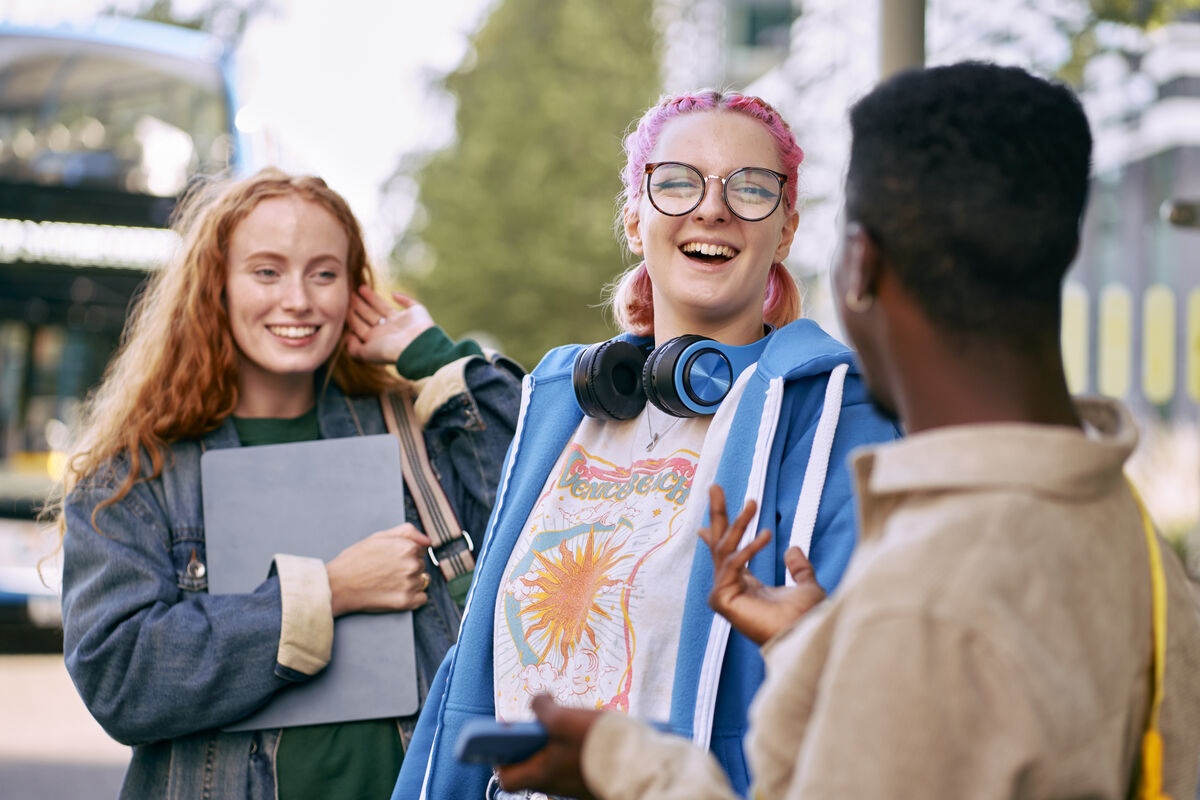 Three students waiting for a bus